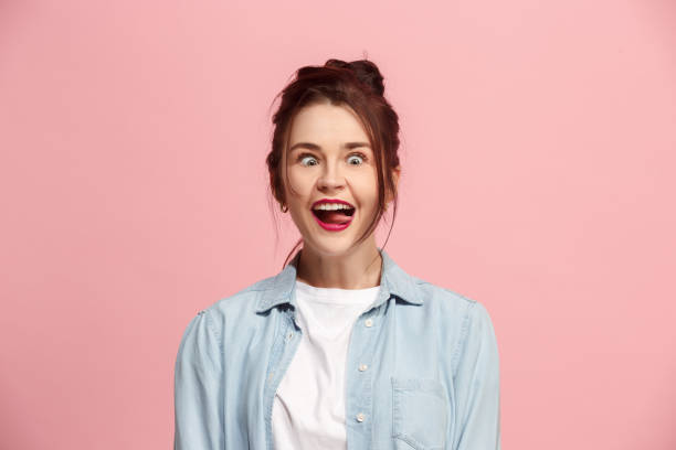 The squint eyed woman with weird expression isolated on pink