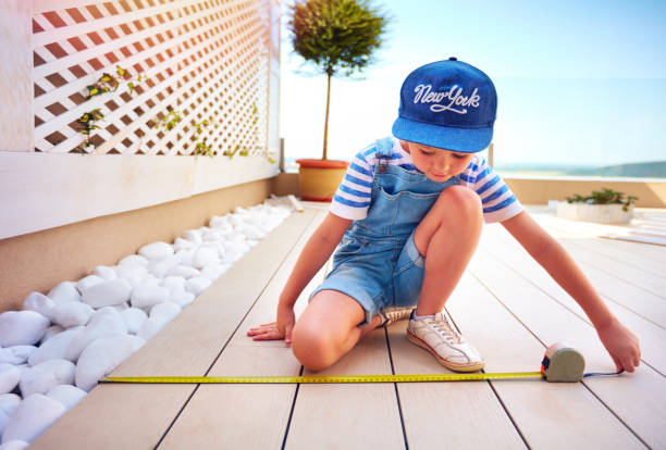 cute young boy, kid halps father with renovation of rooftop patio zone cute young boy, kid halps father with renovation of rooftop patio zone yard measurement stock pictures, royalty-free photos & images