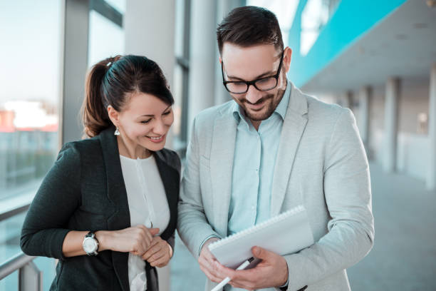 istock Two business people discussing over documents in office lobby. 922530358