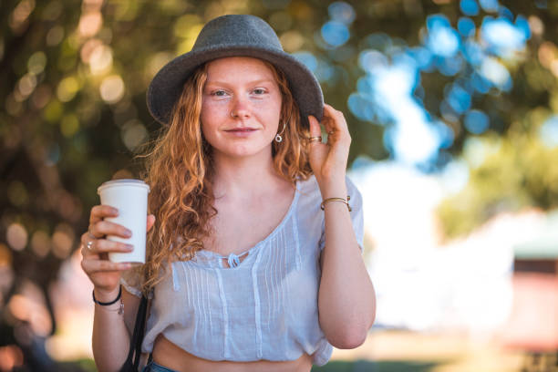istock Young woman enjoying coffee in a park 922531372