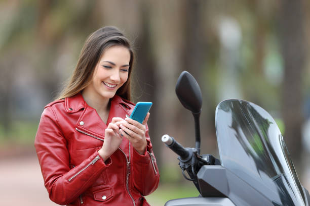 istock Motorbiker using a smart phone on a motorbike 922531610