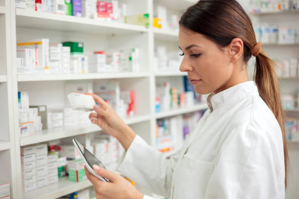 istock Beautiful young pharmacist checking for medications and holding a digital tablet 922534000