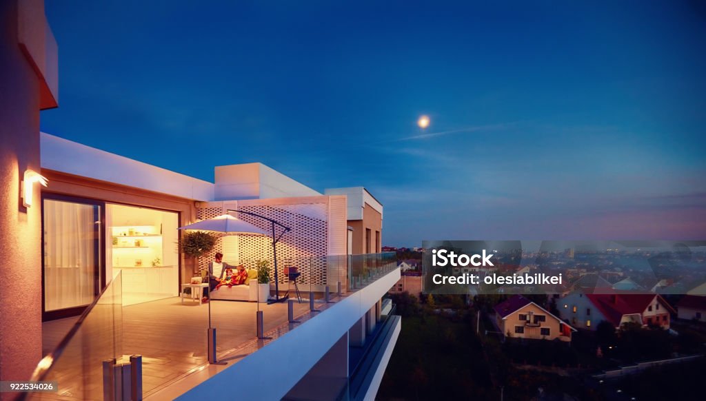 family relaxing on roof top patio with evening city view Apartment Stock Photo