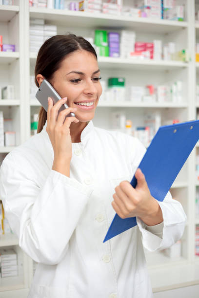 istock Beautiful young pharmacist talking on the phone and holding a clipboard 922534588
