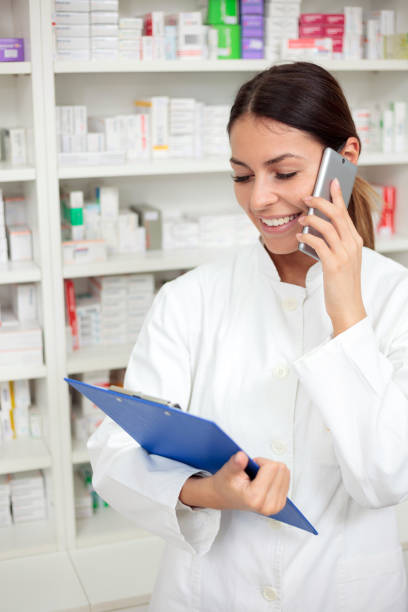 istock Beautiful young pharmacist talking on the phone and holding a clipboard 922534674