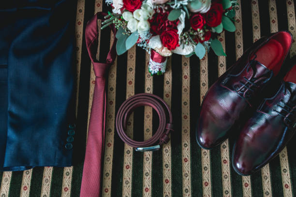 ceinture, cravate, costume, chaussures et bouquet de mariée sur un canapé vintage - chain smoking photos et images de collection