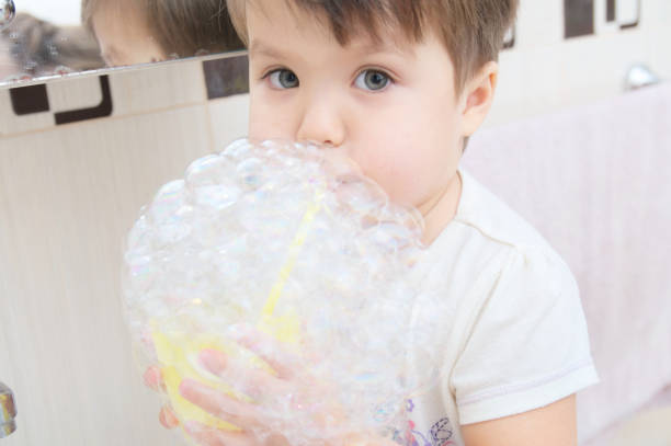 istock Cute little girl playing with soap bubbles 922535016