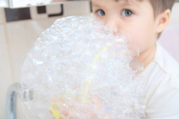 istock Cute little girl playing with soap bubbles 922535162
