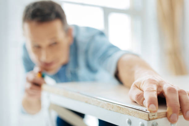 istock Close up of young man using a tape measure 922535656