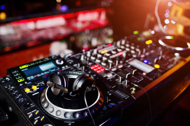 istock DJ spinning mixing and scratching track controls on dj's deck strobe. Dj Music club life concept. 922536192