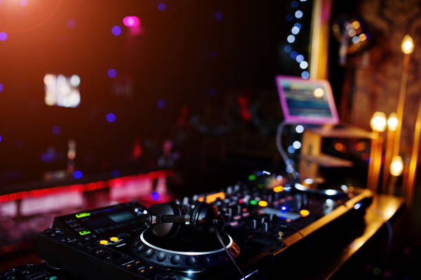 istock DJ spinning mixing and scratching track controls on dj's deck strobe. Dj Music club life concept. 922536236