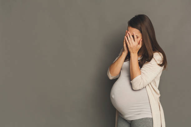 istock Crying pregnant woman, gray studio background 922539066