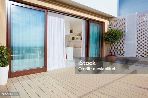 istock roof top patio with open space kitchen, sliding doors and decking on upper floor 922540108
