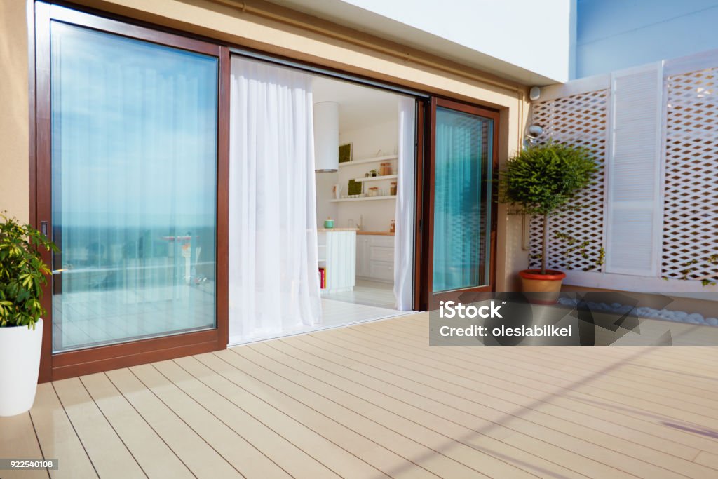 roof top patio with open space kitchen, sliding doors and decking on upper floor Patio Stock Photo