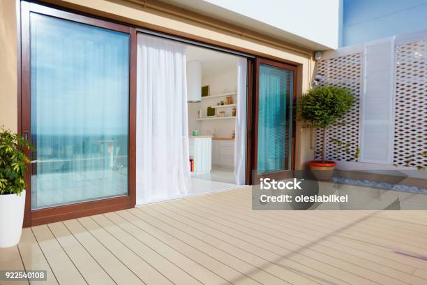 Roof Top Patio With Open Space Kitchen Sliding Doors And Decking On Upper Floor Stock Photo - Download Image Now