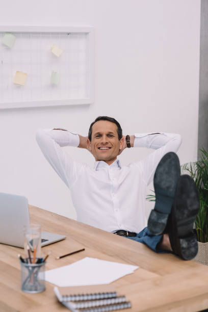 istock handsome happy businessman relaxing at workplace at office 922543094