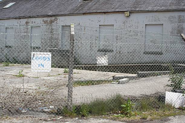 istock Goods In Sign On Fence Around Derelict Site 92254374