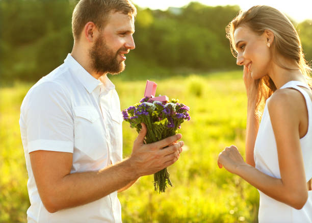 man tut auf der natur engagement mädchen, überraschung, emotion, sonnenuntergang - young women wedding married engagement ring stock-fotos und bilder