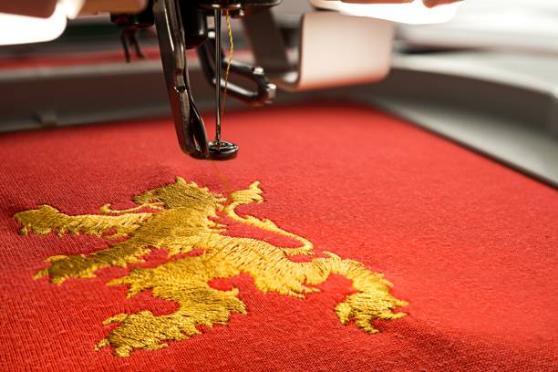 close up picture of workspace embroidery machine and gold lion design - embroidery seam shirt sewing imagens e fotografias de stock