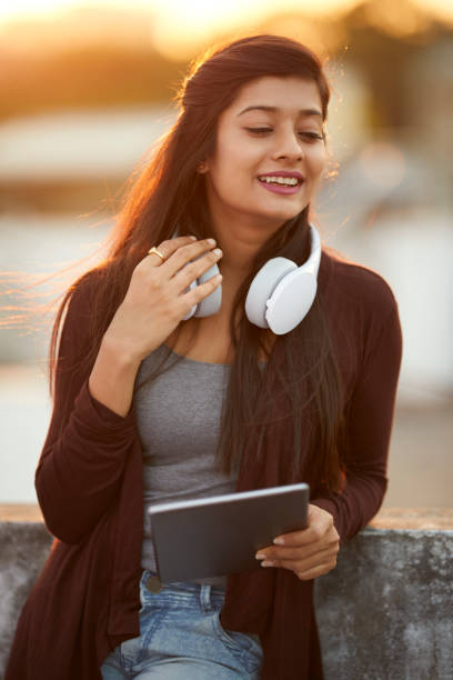istock Beautiful happy young woman using headphone and tablet 922546456