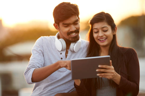 istock Cheerful young friends using tablet with headphones 922546478
