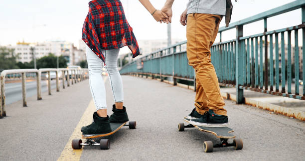 istock Young attractive couple riding skateboards and having fun 922546480