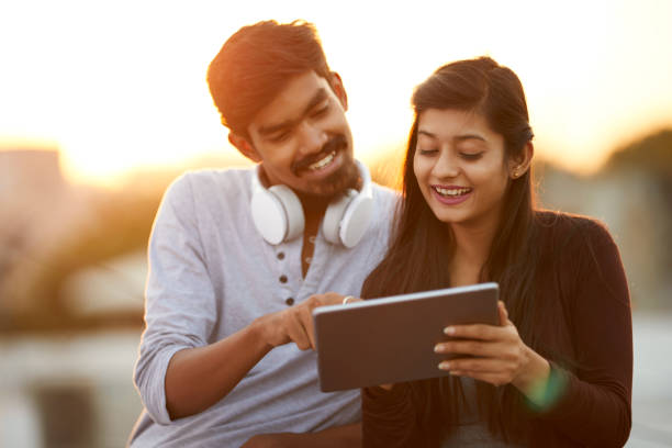 istock Cheerful young friends using tablet with headphones 922546488