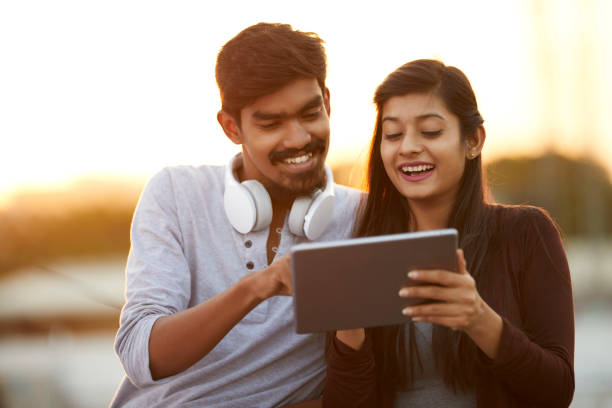 istock Cheerful young friends using tablet with headphones 922546492