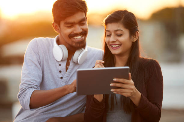 istock Cheerful young friends using tablet with headphones 922546510