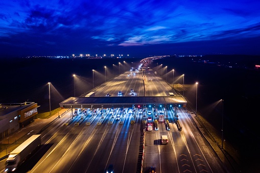Aerial drone view on motorway with toll collection point at night