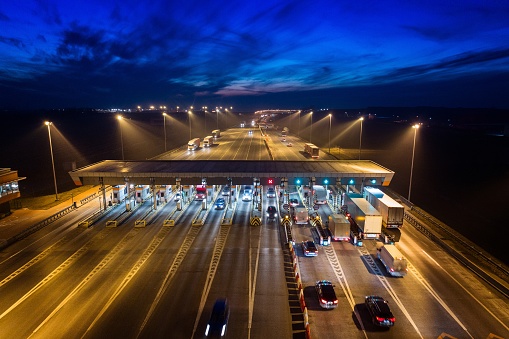 Aerial drone view on toll collection point on motorway at night.
