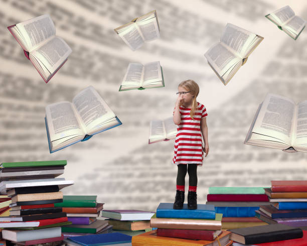 istock A small child with glasses standing among the books 922551302