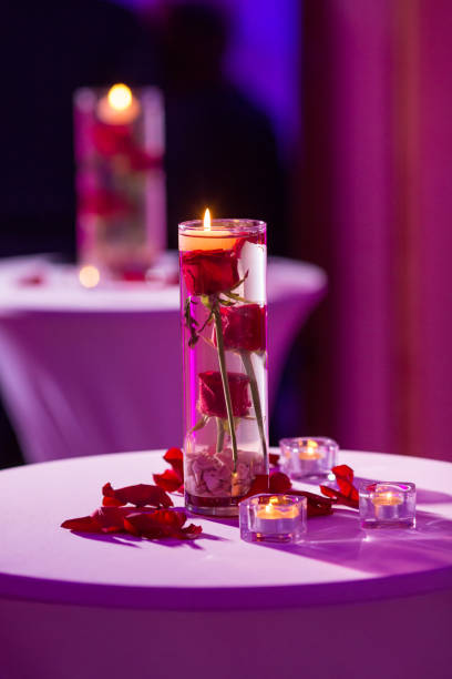 istock Glass vase with red roses water and light candles 922551542