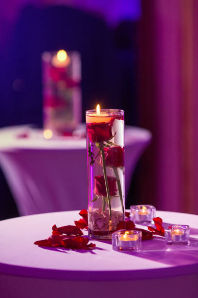 istock Glass vase with red roses water and light candles 922551640