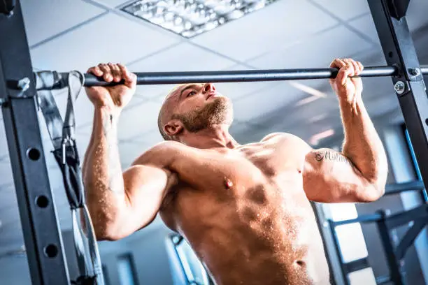 Photo of Muscular strong man training at a gym.