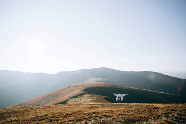Photo of drone copter flying with digital camera in mountains
