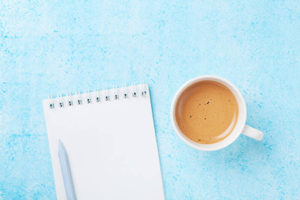 istock Morning coffee, pencil and clean notebook on blue pastel table top view. Planning and design concept for blogging. 922552684