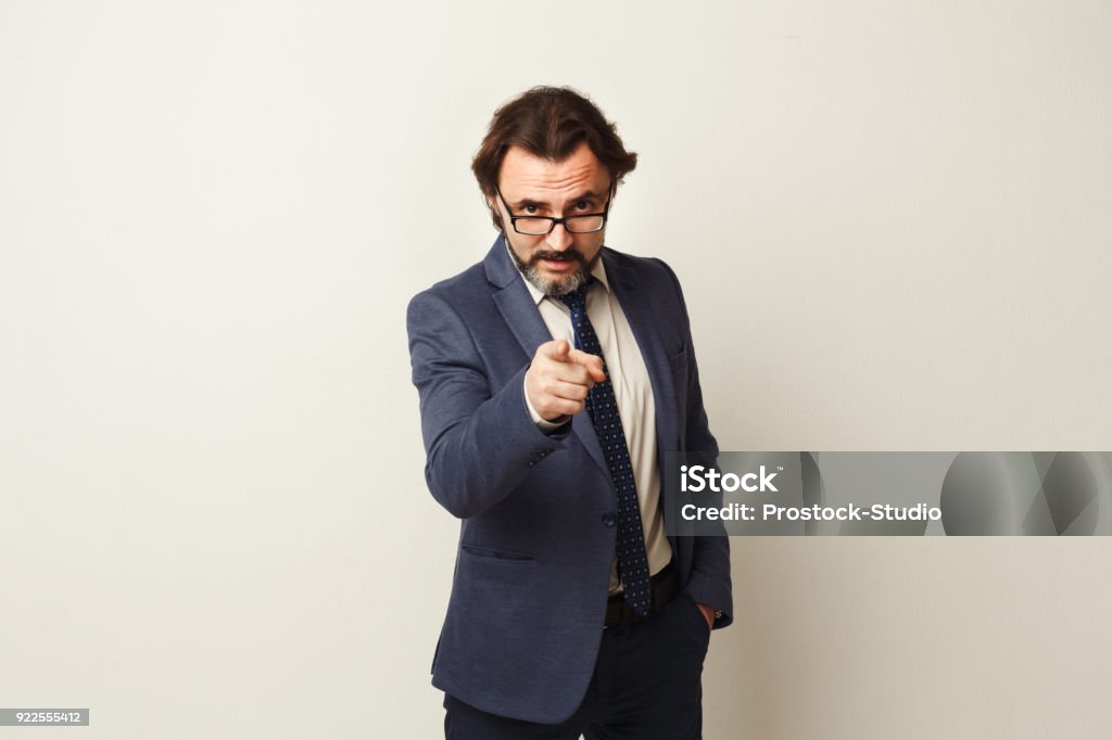 Confident businessman point at camera You are the next. Confident businessman in suit point at camera, standing against white studio background. Motivation concept Pointing Stock Photo
