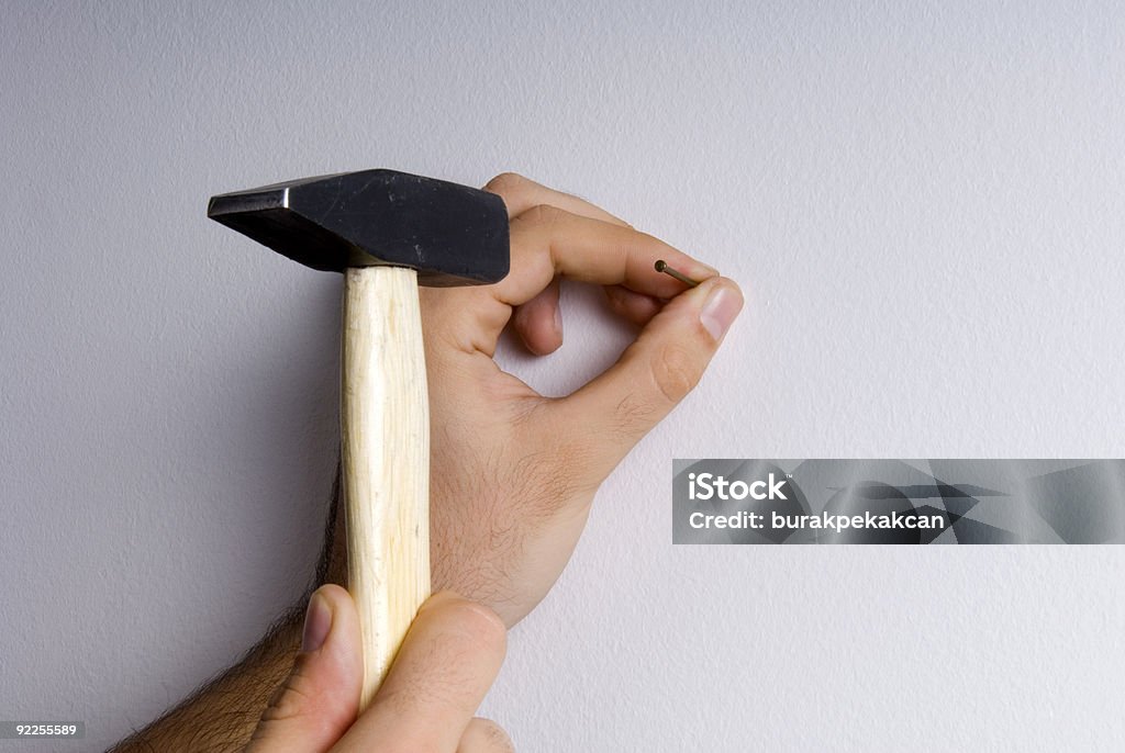 Nahaufnahme der Hände Hämmern einen Nagel auf Mauer - Lizenzfrei Hammer Stock-Foto