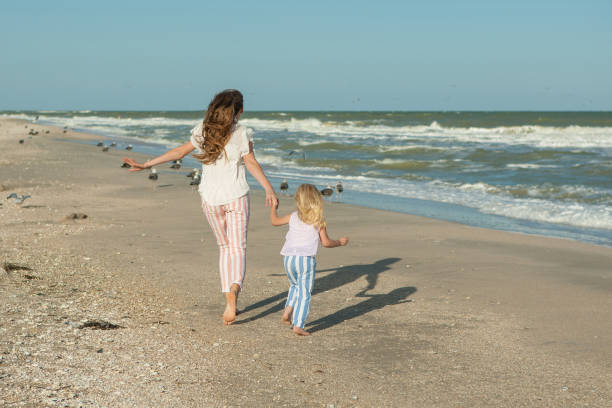 istock Mother and daughter having fun playing on the beach 922556316