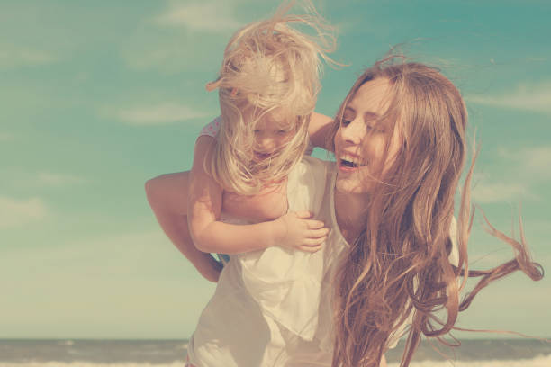 istock Mother and daughter having fun playing on the beach 922556596