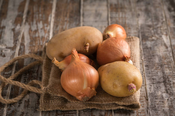 Red onion and potato on the wood background stock photo