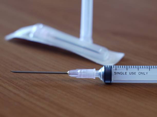 istock injection needle syringe on wooden table with 