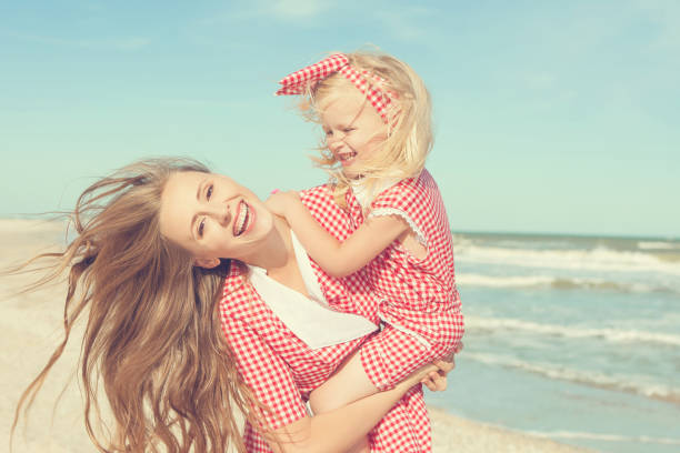 istock Mother and daughter having fun playing on the beach 922558974