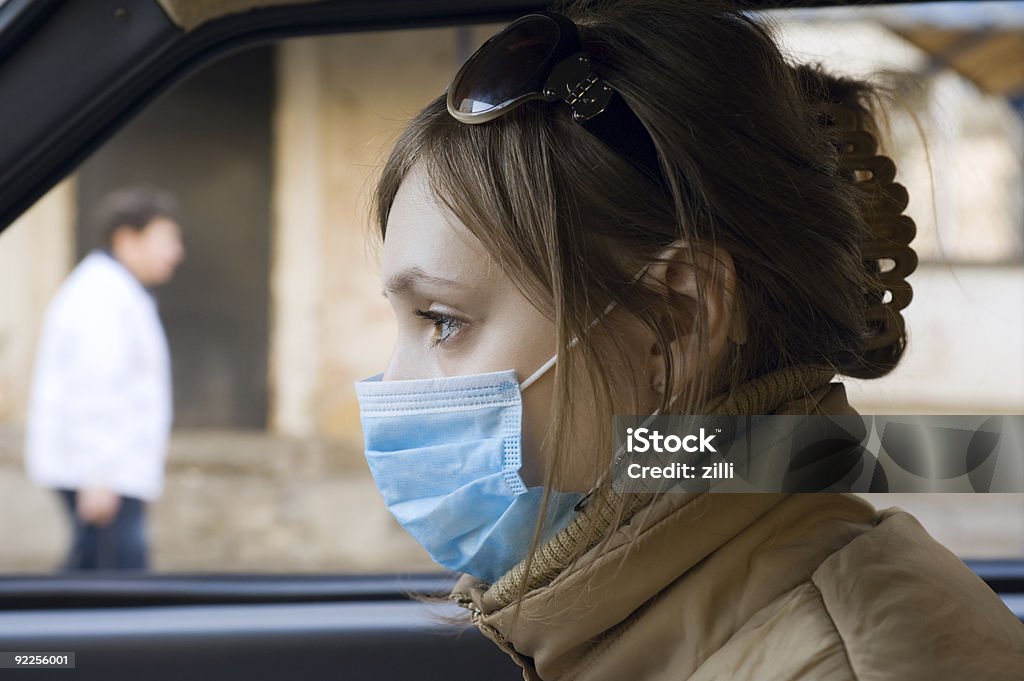 Mujer joven viaje en automóvil de una máscara protectora - Foto de stock de Adolescente libre de derechos