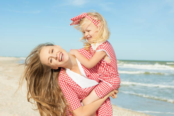 istock Mother and daughter having fun playing on the beach 922561098