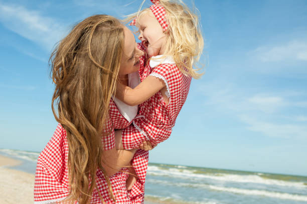 istock Mother and daughter having fun playing on the beach 922561176