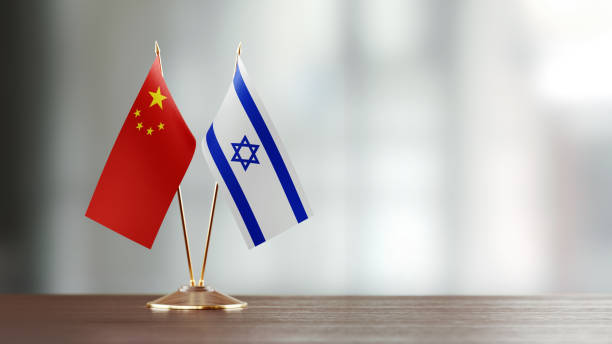 istock Israeli And Chinese Flag Pair On A Desk Over Defocused Background 922561934