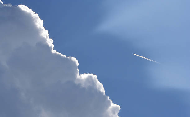istock Beautifully lit Cloud with blue sky and a passing plane 92257001
