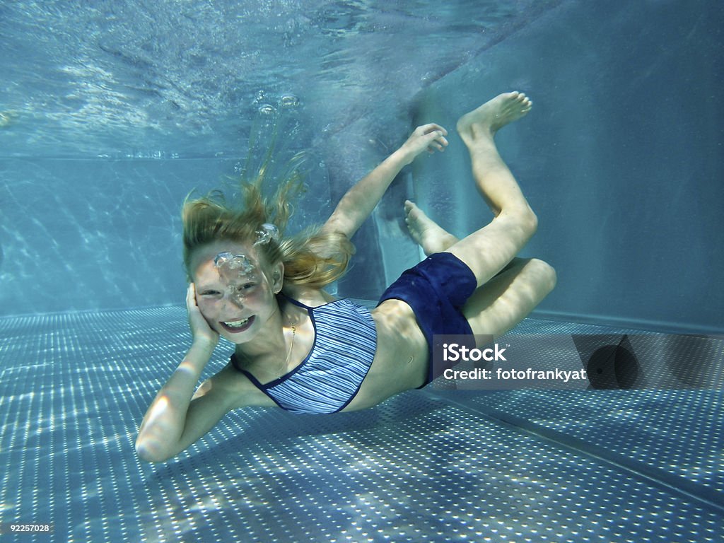 Affascinante bambino sorrisi e tuffarsi in piscina - Foto stock royalty-free di 8-9 anni